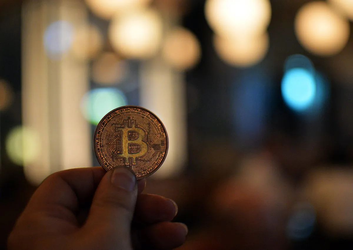 A man holds a bitcoin medal as members of bitcoin trading club hold a meeting in Tokyo on February 27, 2014. (YOSHIKAZU TSUNO/AFP/Getty Images)