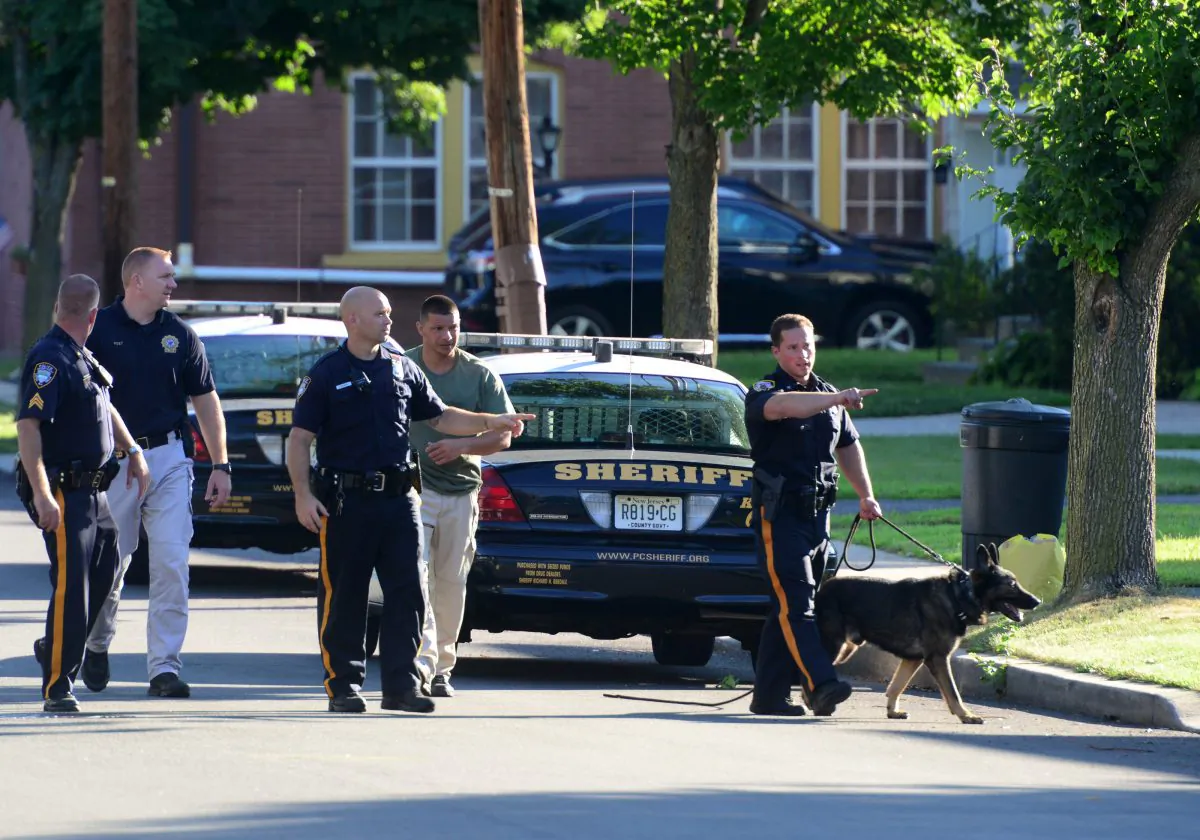 Little Falls Police and a Passaic County Sheriff Department K-9 Unit conduct a search for a burglary suspect on Lincoln Ave, Wednesday, July 22, 2015, in Little Falls, NJ. (Tariq Zehawi/The Record of Bergen County via AP)
