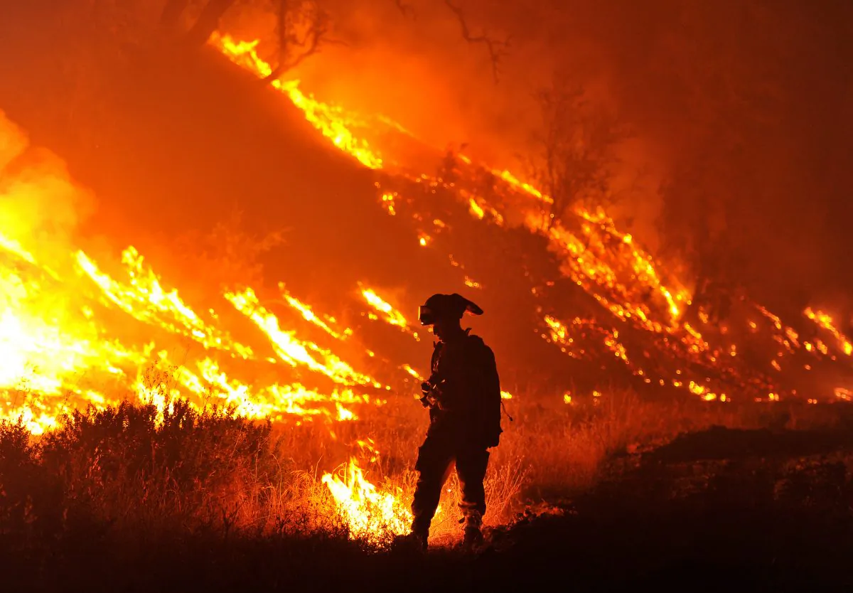 CalFire firefighter Bo Santiago lights a backfire as the Rocky fire burns near Clearlake, Calif., on Monday, Aug. 3, 2015. (AP Photo/Josh Edelson)