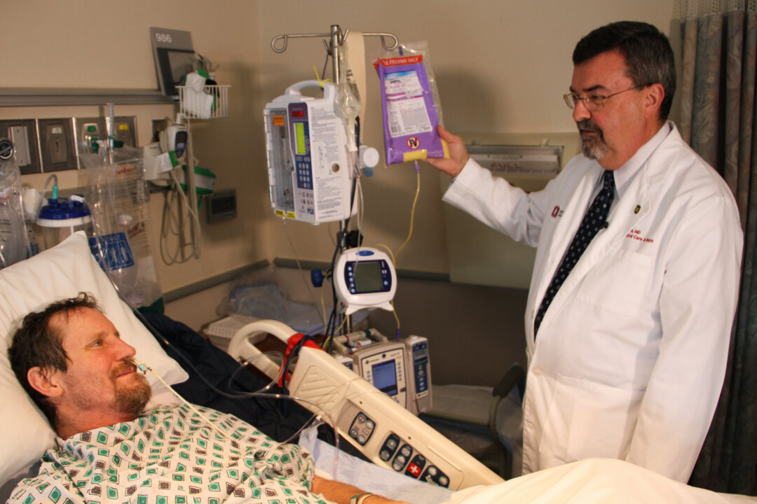Dr. Larry Jones administers a high-protein, high-calorie supplement to a patient in the burn center at The Ohio State University Wexner Medical Center. (Photo courtesy of Wexner Medical Center)