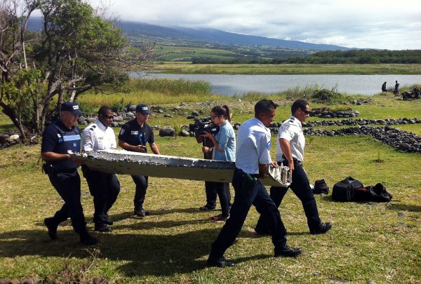 Police carry a piece of debris found in the coastal area of Saint-Andre de la Reunion, in the east of the French Indian Ocean island of La Reunion, which has been identified as part of missing Malaysian Air MH370 on July 29, 2015. (Yannick Pitou/AFP/Getty Images)