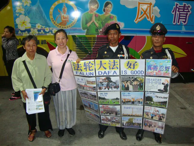 Two local police hold a Falun Gong banner, with two Falun Gong practitioners, in Bangkok, Thailand, 2010. (Epoch Times)
