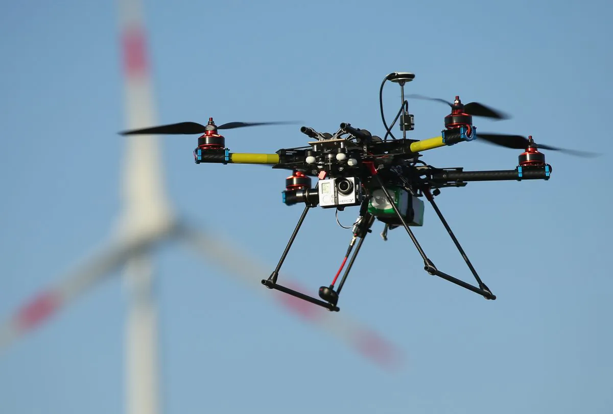 A multirotor quadcopter drone used for aerial photography flies near a wind turbine on June 7, 2011 near Zeestow, Germany. (Sean Gallup/Getty Images)