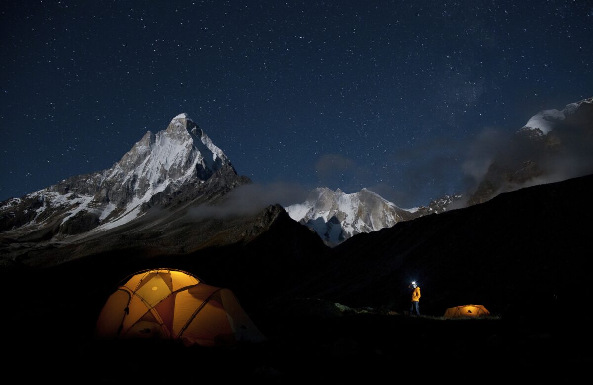 man walks to illuminated tent in Meru