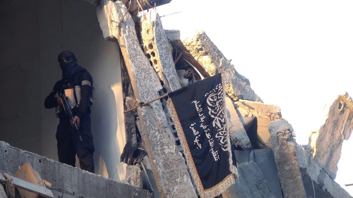 An extremist from ISIS is next to the group's flag in the south of Damascus, Syria, on Sept. 22, 2014. (Rami al-Sayed/AFP/Getty Images)