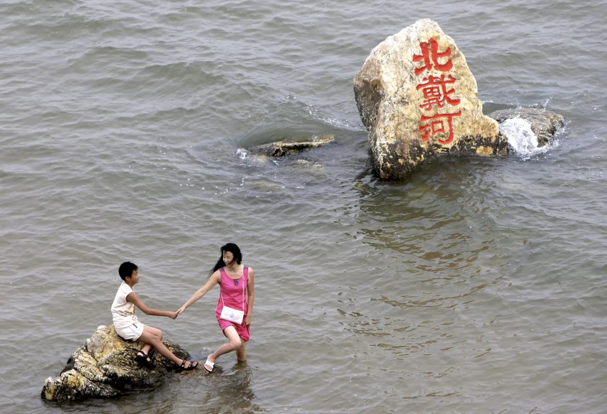 The Chinese characters in red on the rock read: "Beidaihe." Photo from Aug. 8, 2008. (AP Photo/Silvia Izquierdo)