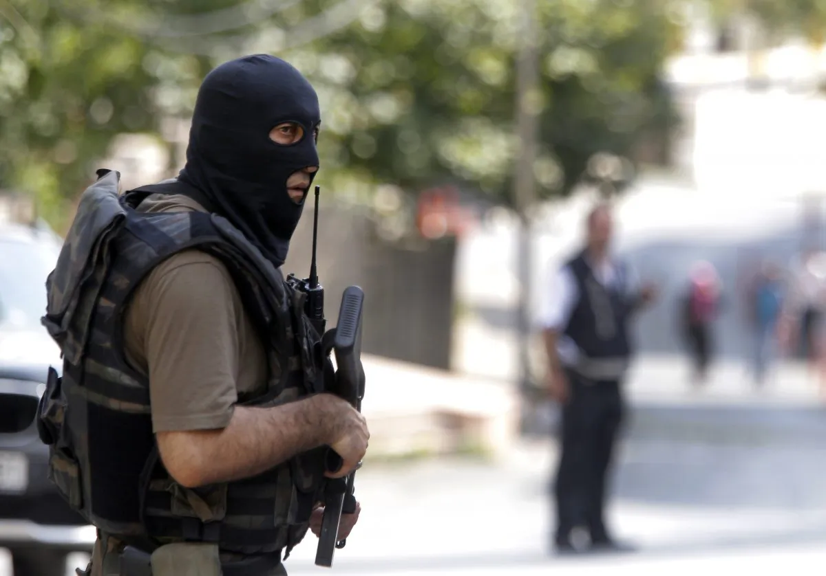 A masked Turkish police officer secures a road leading to the U. S. Consulate building in Istanbul, Monday, Aug. 10, 2015. (AP Photo/Lefteris Pitarakis)