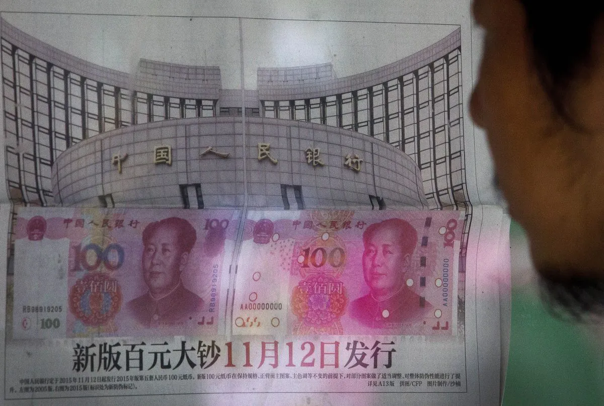 A man reads a newspaper report that China's central bank announced it will devalue China's tightly controlled currency on Aug. 11, 2015 following a slump in trade, triggering the yuan's biggest one-day decline in a decade. (AP Photo/Andy Wong)