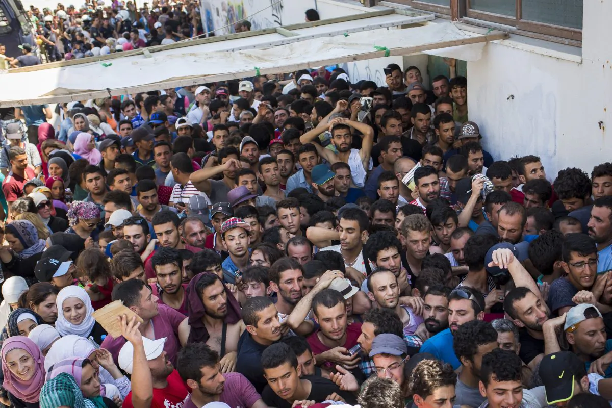 Syrian migrants and refugees gather at a makeshift migrant detention center at an abandoned football stadium on Kos Island, Greece, on Aug. 12, 2015. (Alexander Zemlianichenko/AP)