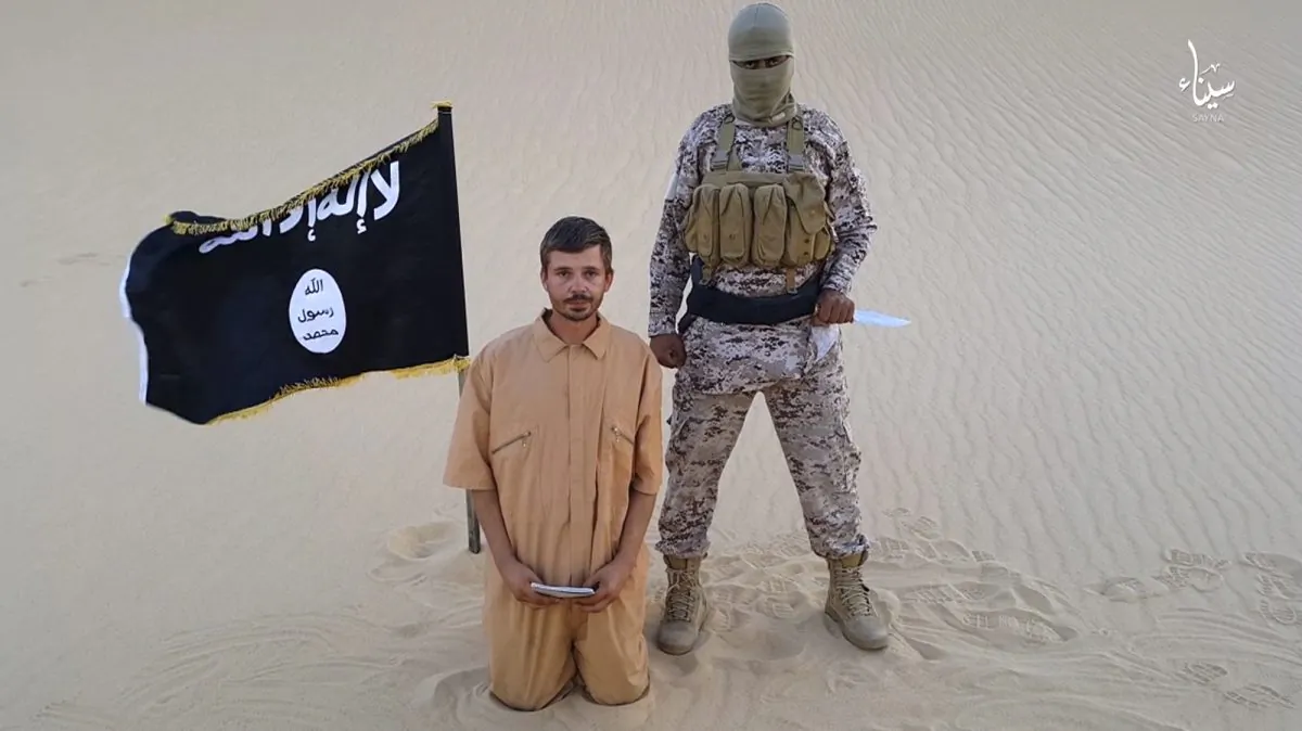 This image made from a militant video posted on a social media site on Wednesday, Aug. 5, 2015, which has been verified and is consistent with other AP reporting, purports to show a militant standing next to another man who identifies himself as 30-year-old Tomislav Salopek, kneeling down as he reads a message at an unknown location. (Militant video via AP)
