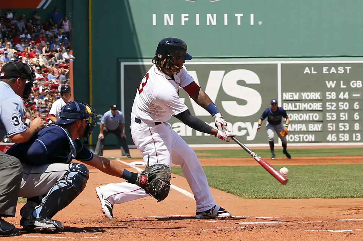 Boston Red Sox's Hanley Ramirez connects on an RBI sacrifice fly out during the first inning of a baseball game against the Tampa Bay Rays at Fenway Park in Boston, Saturday, Aug. 1, 2015. (AP Photo/Winslow Townson)