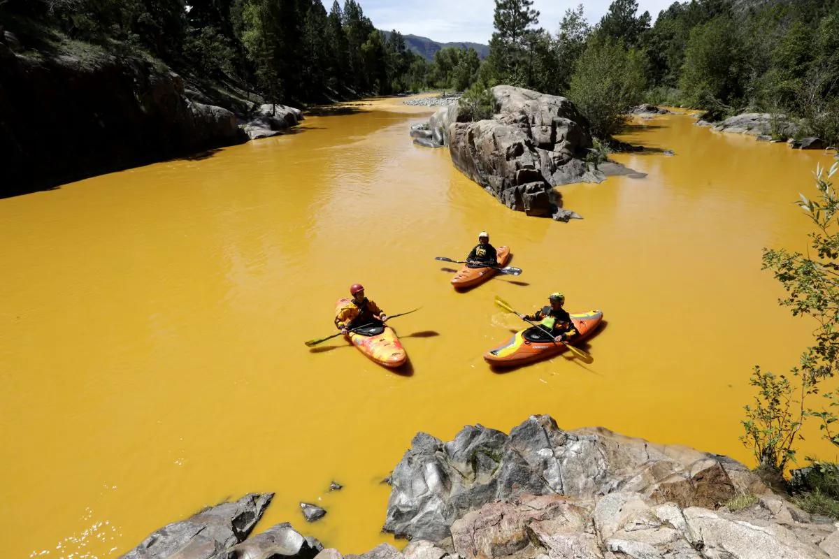 People kayak in the Animas River near Durango, Colo., on Aug. 6, in water colored from a mine waste spill. (Jerry McBride/The Durango Herald via AP)