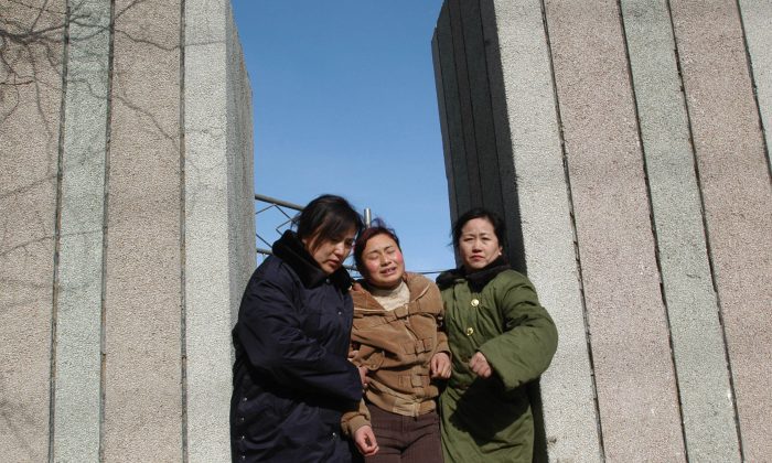 A woman walks out of a building with friends after recognizing the body of her relative who died at the Sunjiawan Coal Mine accident on February 17, 2005 in Fuxin of Liaoning Province, northeast China.  (China Photos/Getty Images)