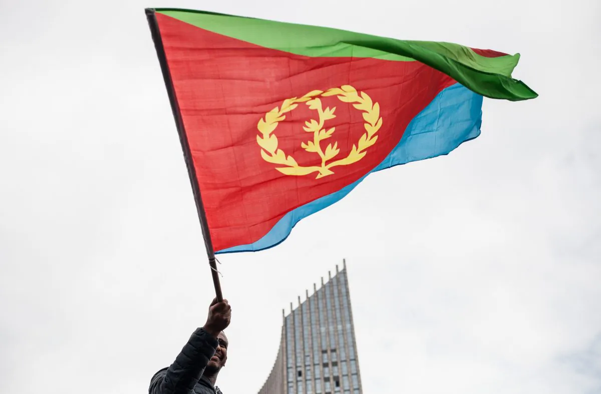 A man waves an Eritrean national flag as hundreds of Eritreans demonstrate in front of the African Union headquarters in support of the U.N. Inquiry report and asking for measures to be taken against Eritrea's human rights violations, in Addis Ababa, on June 26, 2015. (Nichole Sobecki/AFP/Getty Images)