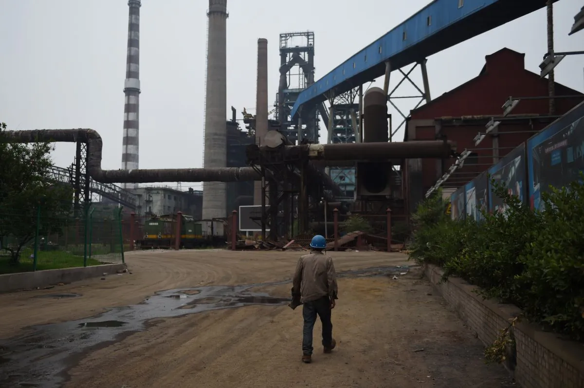 This photo taken on May 28, 2015 shows a demolition worker walking near abandoned buildings at the Shougang Capital Iron and Steel plant in Beijing. Chinese scholar Liu Shijin says that China's economy is at its ebb. (Greg Baker/AFP/Getty Images)
