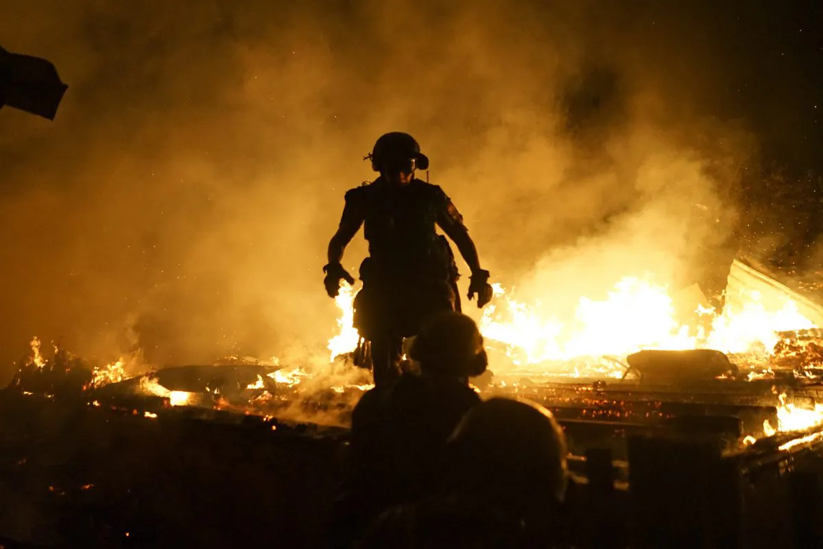 Firefighters extinguish fire at a house destroyed by night-long shelling in Donetsk, eastern Ukraine, on Aug. 16, 2015. (AP Photo/Mstyslav Chernov)