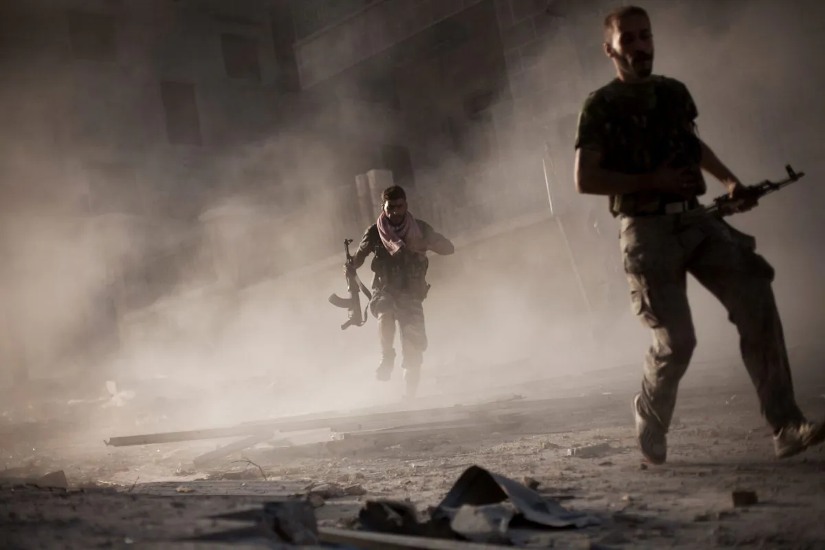 Free Syrian Army fighters run after attacking a Syrian Army tank during fighting in the Izaa District in Aleppo, Syria, on Sept. 7, 2012. (Manu Brabo/AP)