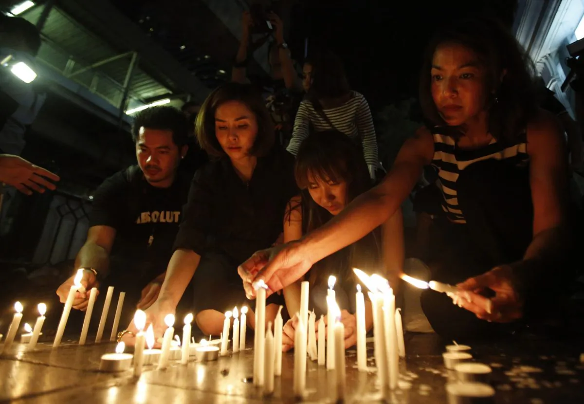 Thai people light candles near the Erawan Shrine at Rajprasong intersection for the victims the day after an explosion in Bangkok, Thailand, Tuesday, Aug. 18, 2015. (AP Photo/Sakchai Lalit)