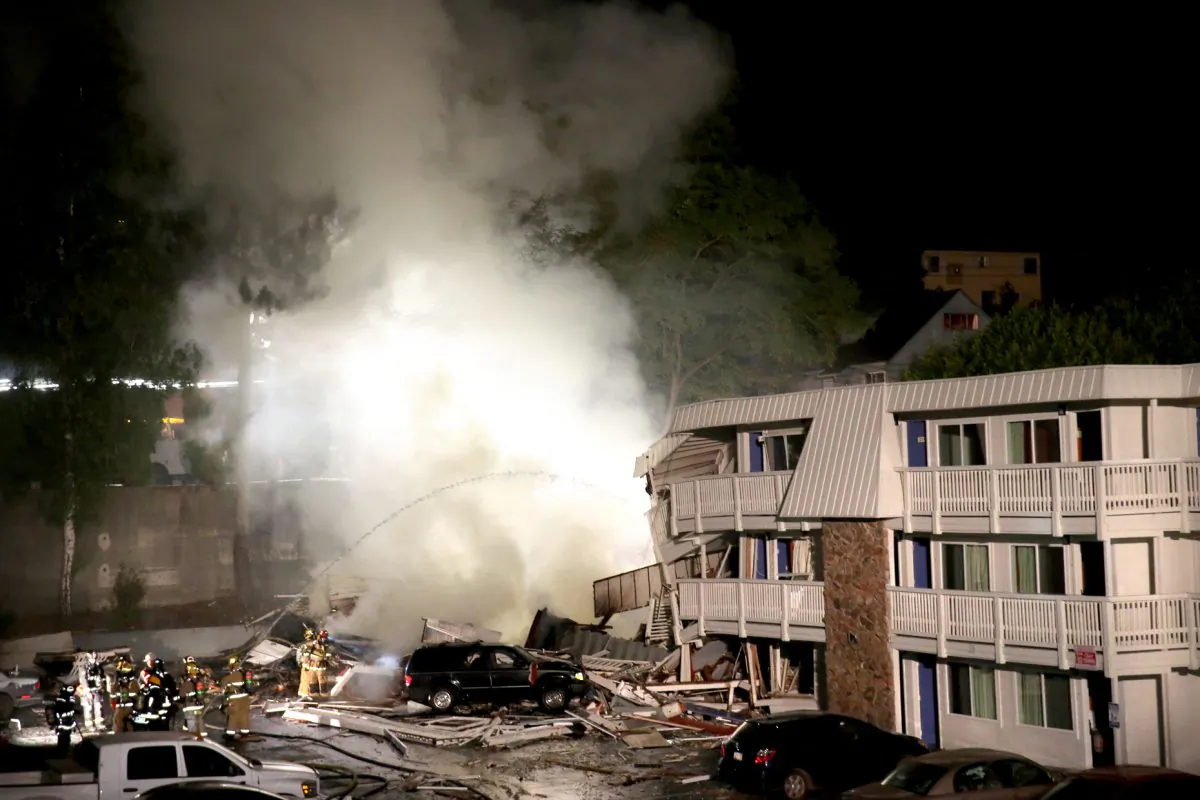 Firefighters cool down hot spots after an explosion at a Motel 6, Tuesday, Aug. 18, 2015, in Bremerton, Wash. (Larry Steagall/Kitsap Sun via AP)