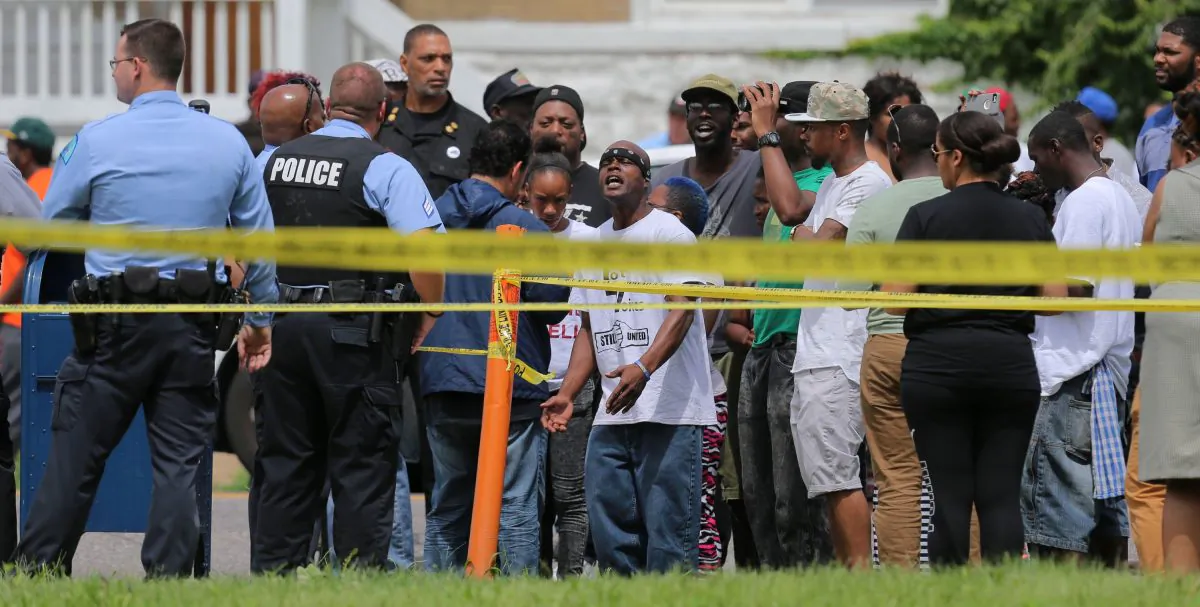People confront police at the scene of a fatal officer-involved shooting at Walton Avenue and Page Boulevard on Wednesday, Aug. 19, 2015, in St. Louis. (David Carson/St. Louis Post-Dispatch via AP)