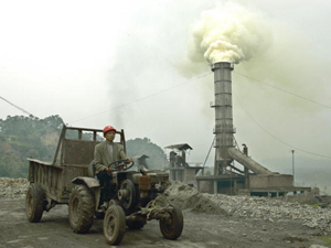 A worker drives a tractor near a smokestack at a cement factory in China&#039s southwestern Sichuan province. (Liu Jin/AFP/Getty Images)