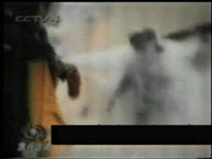 The following 3 sequences, taken from CCTV's own footage shows that Ms. Liu may not have died from the flames, but instead by a blow to the head, delivered by a man in a military overcoat. (NTDTV's False Fire video, showing footage from China Central Television)