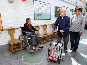 Retired resident Wang Zhehua, 65 (R), walks with her roomate Han Ruilan, 93 (C), at the Jia De Apartments for the elderly, on the outskirts of Beijing. (Frederic J. Brown/AFP/Getty Images)