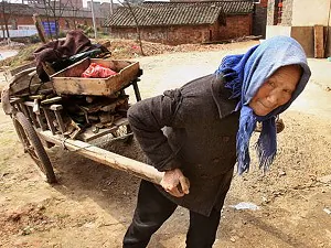 An elderly Chinese woman collects scraps of wood for cooking, near the Yangtze river city of Jiujiang. (Mark Ralston/AFP/Getty Images)