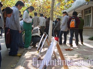 Students viewing Sun Wenguang's campaign display boards. (The Epoch Times) Students viewing Sun Wenguang's campaign display boards. (The Epoch Times)