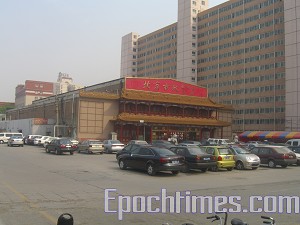 The curio shopping mall on the north side is located 30 meters away from Gao's home. Judging by the vehicle number plates at least one third of the cars parked there belong to the police monitoring Gao's family. (The Epoch Times) The curio shopping mall on the north side is located 30 meters away from Gao's home. Judging by the vehicle number plates at least one third of the cars parked there belong to the police monitoring Gao's family. (The Epoch Times)