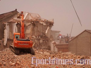 Workers using heavy machinery destroy homes and businesses. (The Epoch Times) 