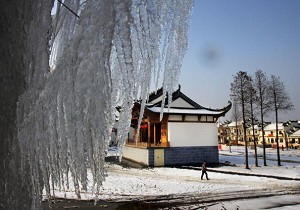 Villagers walk past snow covered Hui-Style buildings in the Hongshiliu Village February 2, 2008 in the outskirts of Wuhan of Hubei Province, China. (China Photos/Getty Images)