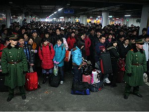 Passengers stranded due to heavy snow queue to board trains in the underground garage converted to a temporary waiting area, at the Shanghai Railway Station. (China Photos/Getty Images)