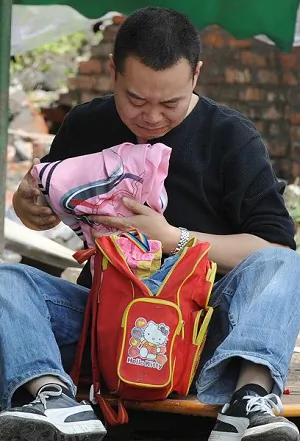 A father crying while looking through the school bag of his child. (MARK RALSTON/AFP/Getty Images) 