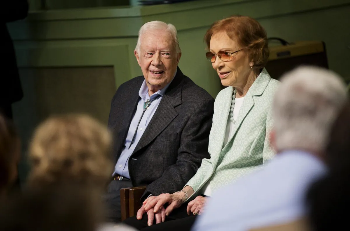 Former President Jimmy Carter, left, sits with his wife Rosalynn as they pose for photos after Carter taught Sunday School class at Maranatha Baptist Church in his hometown Sunday, Aug. 23, 2015, in Plains, Ga. (AP Photo/David Goldman)