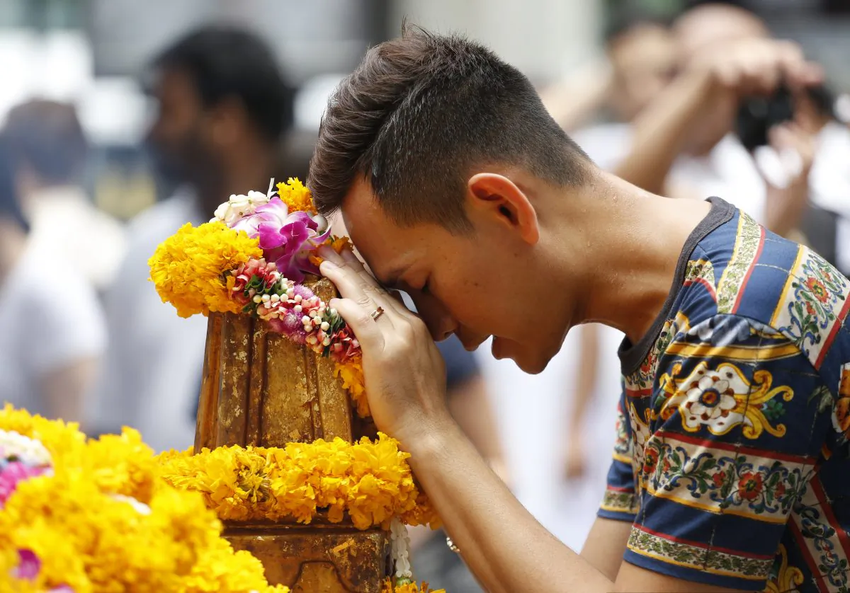 A man prays at the Erawan Shrine at Rajprasong intersection, the scene of last week's bombing, in Bangkok, Thailand, Monday, Aug. 24, 2015. (AP Photo/Sakchai Lalit)