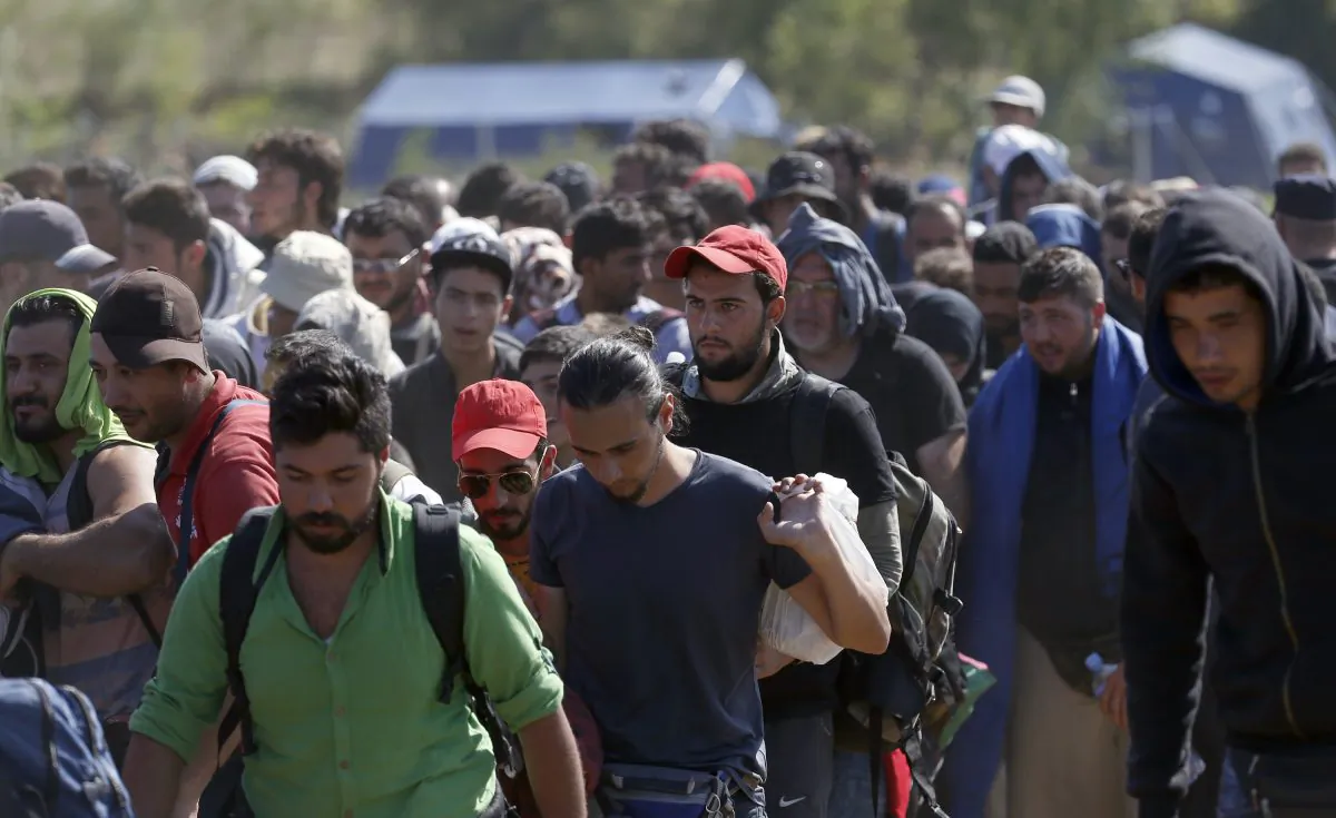 Migrants walk into Serbia over the border with Macedonia near the village of Miratovac, Serbia, Monday, Aug. 24, 2015. The more than 5,000 migrants who reached Serbia overnight faced an overcrowded refugee center where they have to apply for asylum — the paper that allows them three days to reach Hungary. (AP Photo/Darko Vojinovic)