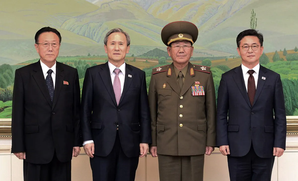 South Korean Unification Minister Hong Yong-pyo (R) and presidential security adviser Kim Kwan-jin (2L) with Kim Yang Gon (2R), a senior North Korean official responsible for South Korean affairs, and Hwang Pyong So (L), North Korea' top political officer for the Korean People's Army, after their meeting at the border village of Panmunjom, in Paju, South Korea, on Aug. 25, 2015. South Korea has agreed to halt propaganda broadcasts at noon Tuesday after North Korea expressed regret over a recent land mine blast that maimed two South Korean troops, both Koreas announced after three days of intense talks aimed at defusing soaring tension between the rivals. (South Korean Unification Ministry via AP)