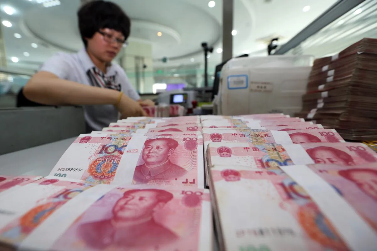 A teller counts yuan banknotes in a bank in Lianyungang, Jiangsu Province, on August 11, 2015. (STR/AFP/Getty Images)