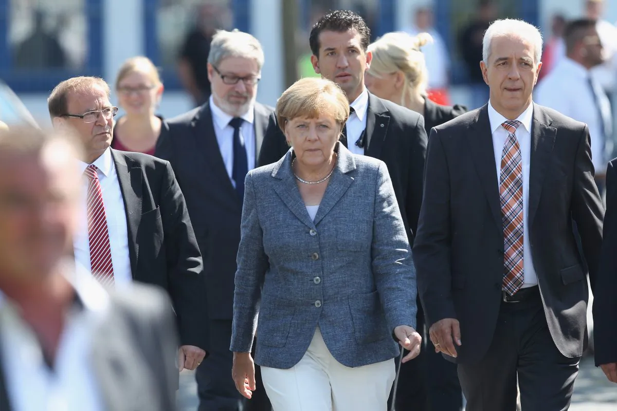 German Chancellor Angela Merkel, flanked by Heidenau Mayor Juergen Opitz and Saxony Governor Stanislaw Tillich, arrives to speak to the media after spending over an hour visiting the aslyum shelter that was the focus of recent violent protests on August 26, 2015 in Heidenau, Germany. (Sean Gallup/Getty Images)