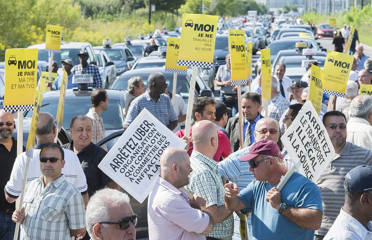 Taxi drivers demonstrate in Montreal after comments made by Quebec Premier Philippe Couillard saying that he'd allow ride-sharing service Uber to operate legally in the province, Aug. 25, 2015. (The Canadian Press/Graham Hughes)