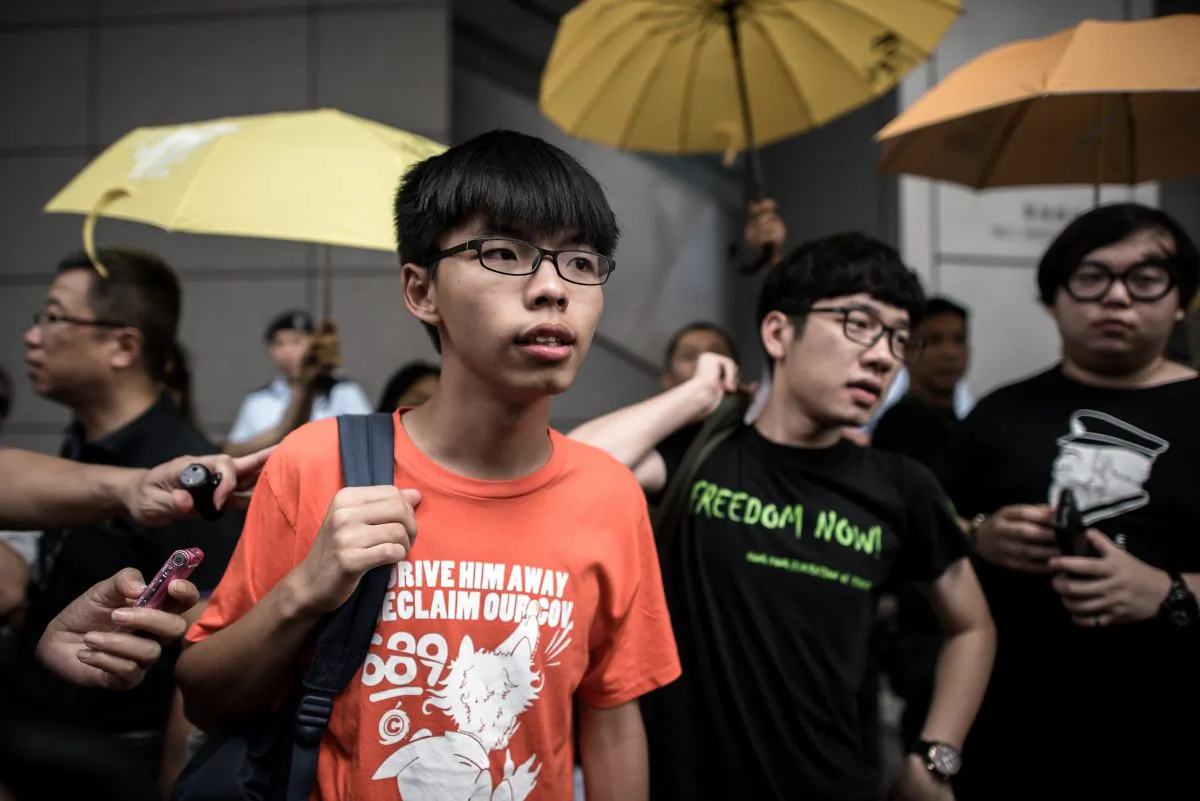 Student protesters Joshua Wong (centre L) and Nathan Law (centre R) stand outside the Wanchai police station in Hong Kong on August 27, 2015. (Philippe Lopez/AFP/Getty Images