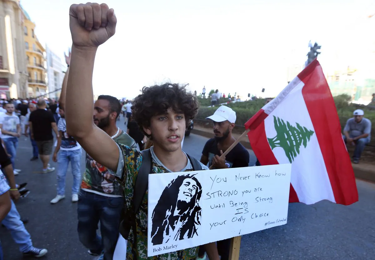 A Lebanese anti-government protester holds a placard, during a demonstration against the trash crisis and government corruption, in downtown Beirut, Lebanon, Saturday, Aug. 29, 2015. (AP Photo/Bilal Hussein)