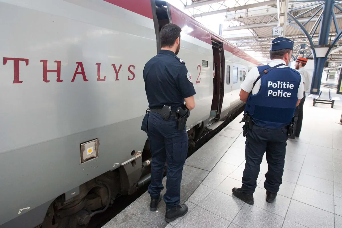 In this Aug.22, 2015 file photo, member of Belgian and French police stay next to a Thalys train at the Brussels Midi - Zuid train station. The attack Aug. 21 on the Thalys train from Amsterdam to Paris happened at the height of the summer travel season. (AP Photo/Francois Walschaerts)