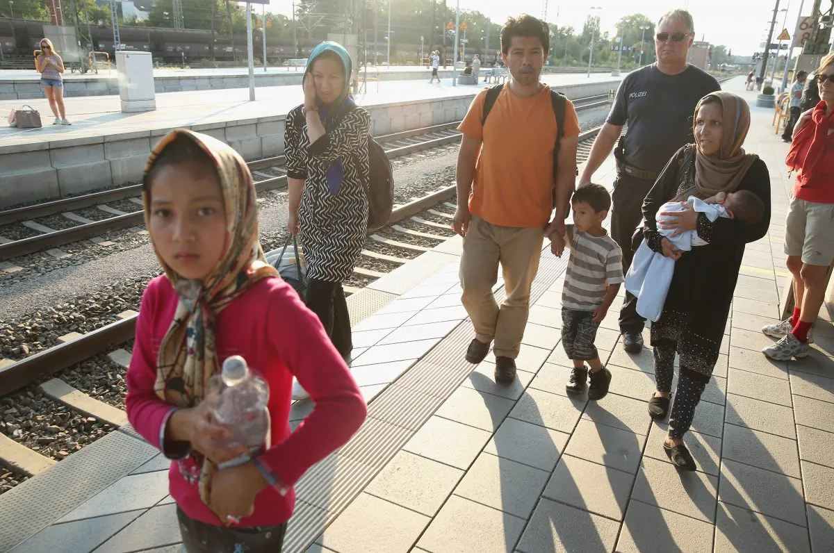 Police escort a family from Afghanistan who were among 190 migrants police detained from a train that arrived from Budapest at Rosenheim railway station on August 31, 2015 in Rosenheim, Germany. (Sean Gallup/Getty Images)