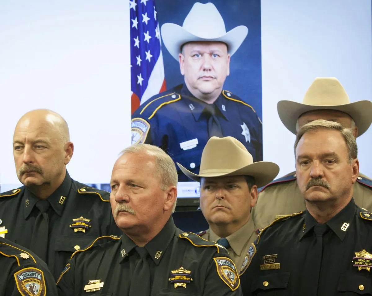 Law enforcement officers attend a news conference regarding the shooting death of Harris County Sheriff's Deputy Darren Goforth, pictured in back, Saturday, Aug. 29, 2015, in Houston. (Marie D. De Jesus/Houston Chronicle via AP) 