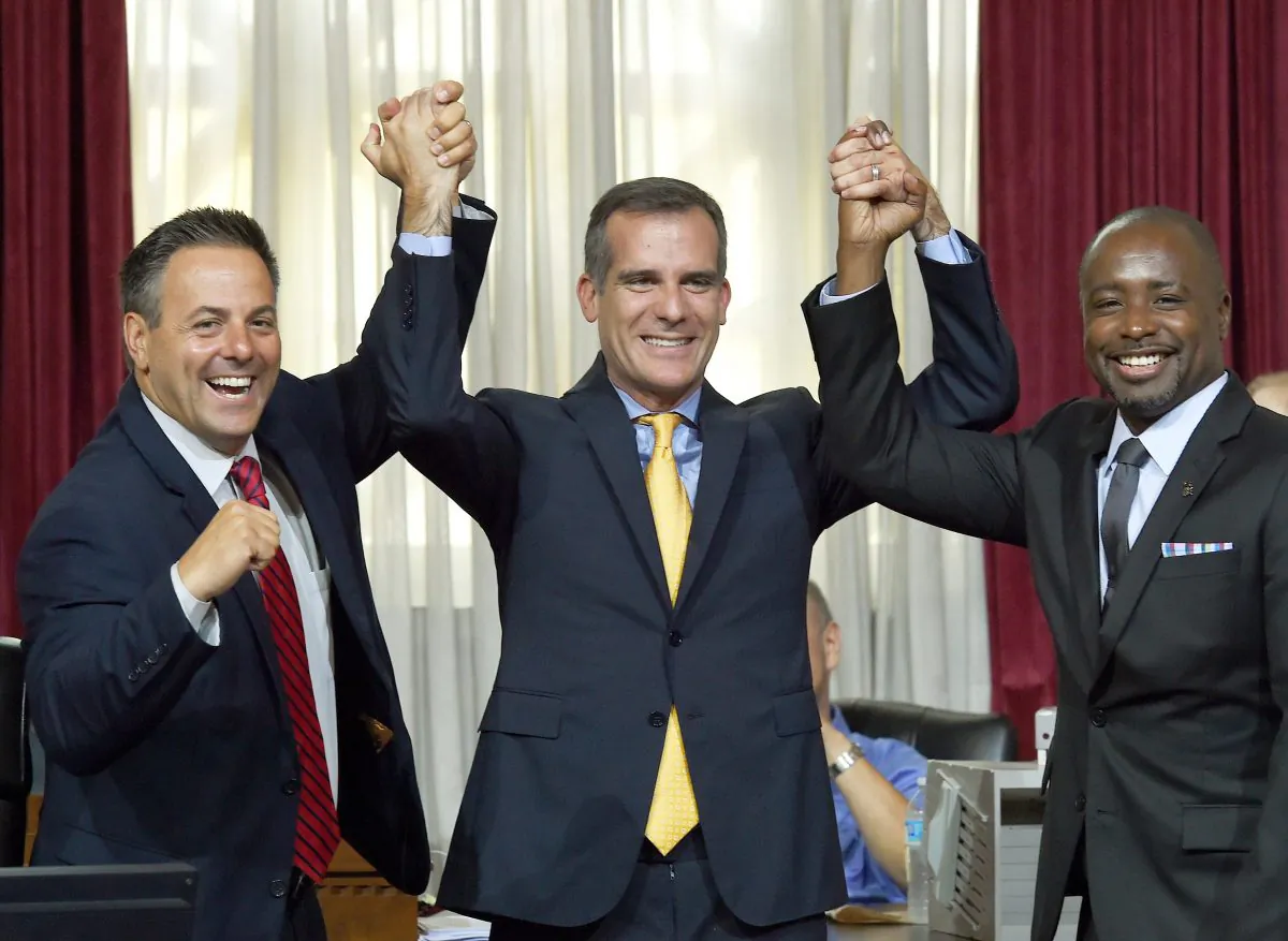 Los Angeles mayor Eric Garcetti (C) celebrates with Los Angeles City Councilmen Joe Buscaino (L) and Marqueece Harris-Dawson (R) after the council voted to bid for the 2024 Summer Olympics, at City Hall in Los Angeles, California on September 1, 2015.  (Mark Ralstone/AFP/Getty Images)