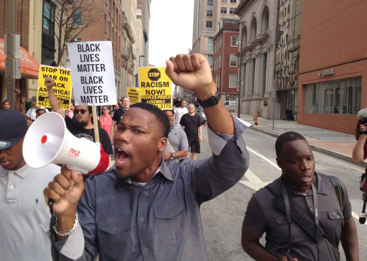 Pastor Westley West, from Faith Empowered Ministries, leads protesters as they march towards Pratt Street and the Inner Harbor, Wednesday, Sept. 2, 2015, in Baltimore, as the first court hearing was set to begin in the case of six police officers criminally charged in the death of Freddie Gray. (Lloyd Fox/The Baltimore Sun via AP) 
