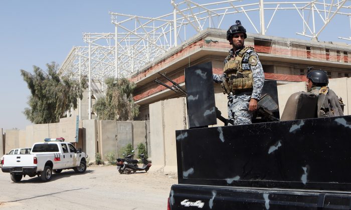 Iraqi security forces guard the entrance to a sports complex being built by a Turkish construction company, in the Shiite district of Sadr City, Baghdad, Iraq, Wednesday, Sept. 2, 2015. (AP Photo/Khalid Mohammed)