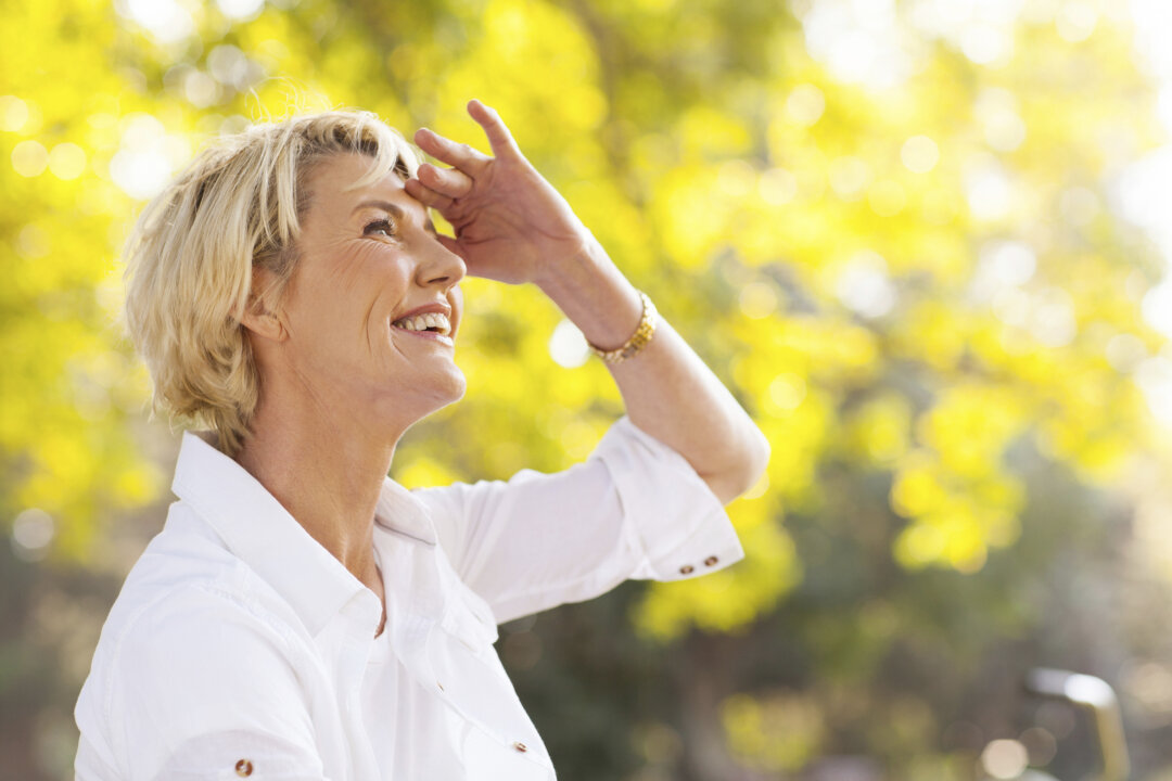 cheerful mature woman looking up outdoors